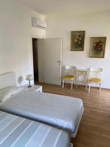 1 Schlafzimmer mit einem Bett, 2 Stühlen und einem Tisch in der Unterkunft Film festival bedroom in Lido di Venezia