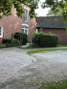 a brick house with a gate in front of it at Haus Tunix in Butjadingen