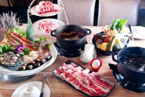 - une table avec de nombreux plats différents dans l'établissement Tsun Huang Hotel, à Chiayi