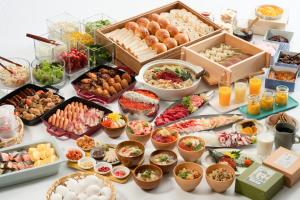 a table topped with lots of different types of food at Vessel Inn Takadanobaba Ekimae in Tokyo