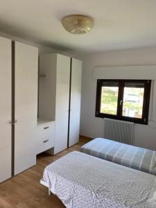 ein Schlafzimmer mit einem Bett, einer Kommode und einem Fenster in der Unterkunft Film festival bedroom in Lido di Venezia