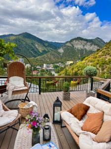 una terraza con sofás y vistas a la montaña. en Hotel Borjomi Verde en Borjomi