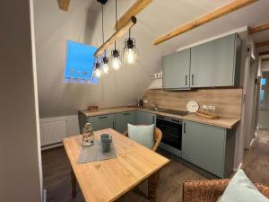 a kitchen with a wooden table and a dining room at Amei's Huuske Wohnung Amelie in Krummhörn
