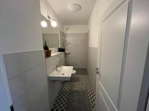 a white bathroom with a sink and a mirror at Amei's Huuske Wohnung Tomma EG in Krummhörn