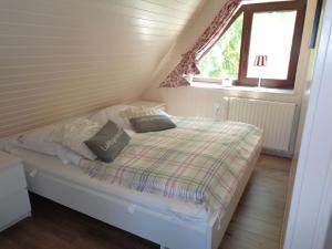 a small bed in a small room with a window at Haus Dat lüttje Huus in Krummhörn