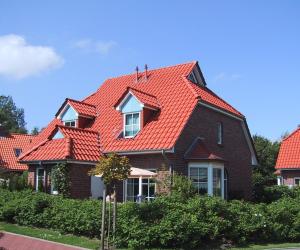 a house with a red roof at Haus Lüttje Huus in Krummhörn