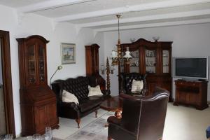 ein Wohnzimmer mit Ledersesseln und einem TV in der Unterkunft Haus Leevke in Pewsum