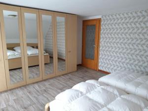 a bedroom with two beds and a closet with mirrors at Haus Leevke in Pewsum
