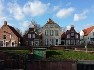a group of houses in a row next to a river at Haus Marie in Krummhörn