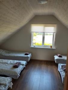 Cette chambre comprend 3 lits et une fenêtre. dans l'établissement Sepa puhkemaja, à Pärnu