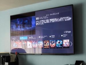 a large screen on a wall with japanese characters on it at Vessel Inn Takadanobaba Ekimae in Tokyo