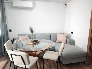 uma sala de estar com uma mesa de vidro e um sofá em Cosy flat a few min to Barcelona emblematic sites em Cornellà de Llobregat