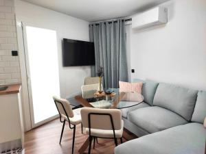 ein Wohnzimmer mit einem Sofa, einem Tisch und Stühlen in der Unterkunft Cosy flat a few min to Barcelona emblematic sites in Cornellà de Llobregat