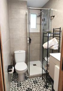 a bathroom with a toilet and a glass shower at Cosy flat a few min to Barcelona emblematic sites in Cornellà de Llobregat