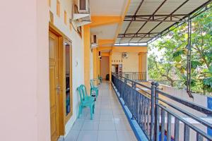 un couloir d'un immeuble avec des chaises sur un balcon dans l'établissement OYO Life 92542 Griya Sakinah Syariah, à Grobogan