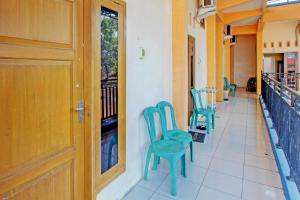un couloir avec des chaises bleues et une porte dans l'établissement OYO Life 92542 Griya Sakinah Syariah, à Grobogan