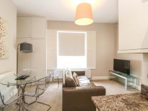 a living room with a couch and a glass table at Apartment 11 Astor House in Torquay