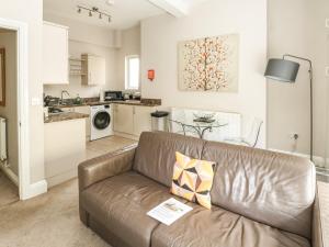 a living room with a couch and a kitchen at Apartment 11 Astor House in Torquay