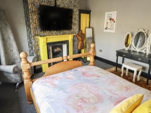 una camera con letto e TV a parete di The Yellow House a Withernsea