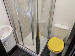 a bathroom with a shower and a yellow toilet at The Yellow House in Withernsea +26 photos
