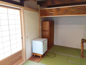 a small refrigerator in a room with a window at 城東蔵ホテルにし乃 #LJ1 in Tuyama