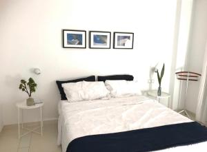 a bedroom with a large white bed with two tables at Casa Las Olas in Palm-mar