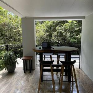 ein Zimmer mit einem Tisch mit Stühlen und einem Laptop darauf in der Unterkunft Loft Mágico en Nativa Resort in Tarcoles