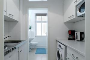 uma cozinha branca com um WC e um lavatório em Grand Central City Apartments Mitte Rosenthaler Platz em Berlim