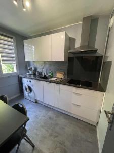 uma cozinha com armários brancos e uma máquina de lavar roupa em ZEN T1, 500m centre, proche gare, tout confort em Châlons-en-Champagne