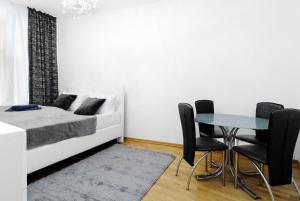 um quarto com uma cama, uma mesa e cadeiras em Grand Central City Apartments Mitte Rosenthaler Platz em Berlim