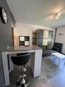 um quarto com uma secretária com uma cadeira e um sofá em ZEN T1, 500m centre, proche gare, tout confort em Châlons-en-Champagne
