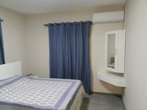 - une chambre avec un lit et un rideau bleu dans l'établissement 3 bedrooms -swimming pool- fully equipped kitchen, à Roches Brunes