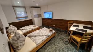 ein Zimmer mit zwei Betten und einem Tisch und einem Fernseher in der Unterkunft Handwerkerwohnung-Monteurunterkunft in Darmstadt