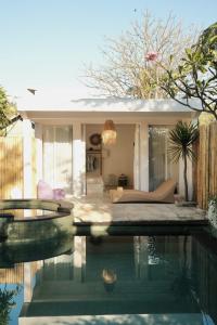 a swimming pool in front of a house at VILLA MENORCA in Gili Trawangan