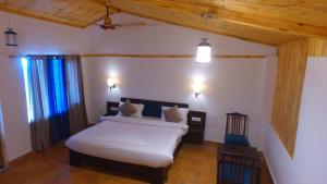 a bedroom with a white bed and a wooden ceiling at Mountain View Resort Nainital in Nainital