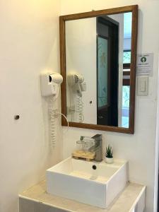 a bathroom with a white sink and a mirror at DENGI INN EL NIDO in El Nido