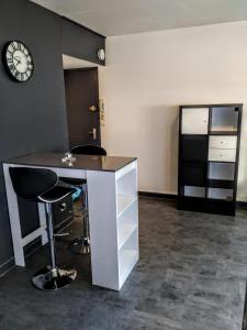 um escritório com uma secretária e um relógio na parede em ZEN T1, 500m centre, proche gare, tout confort em Châlons-en-Champagne