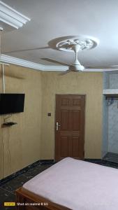 - une chambre avec un ventilateur de plafond et un lit dans l'établissement STUDIO 2 Climatisé et Ventilateur Plafonnier et WIFI GRATUIT A 6 NUITEES DE RESERVATION, à Lomé