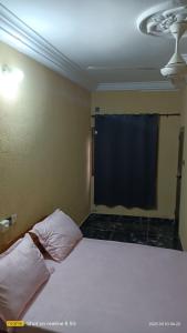 1 dormitorio con cama y pantalla negra en STUDIO 2 Climatisé et Ventilateur Plafonnier et WIFI GRATUIT A 6 NUITEES DE RESERVATION en Lomé
