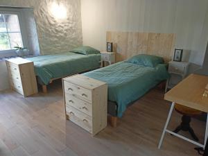 um quarto com 2 camas, uma secretária e uma mesa em Chambres Maison Labourdasse em Saint-Martin-de-Hinx