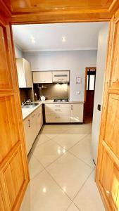 a kitchen with white cabinets and a tile floor at Apartament Lewinek in Lewin Kłodzki