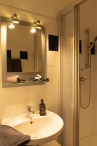 y baño con lavabo y ducha con espejo. en Modern - Calm - Cozy - self CheckIn - stylish new apartment near center - close to U4 en Viena