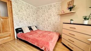 a small bedroom with a bed and a dresser at Apartament Lewinek in Lewin Kłodzki
