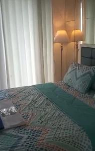 1 dormitorio con 1 cama con edredón verde en Elegance, en Surabaya