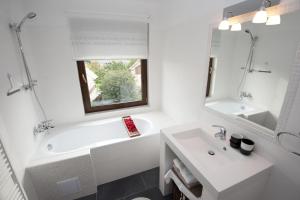 ein Badezimmer mit einer weißen Badewanne, einem Waschbecken und einem Spiegel in der Unterkunft Villa Vinica in Limbach