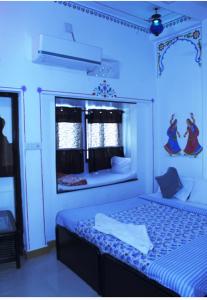 Habitación azul con cama y espejo en The Royal Lake View Villa, en Udaipur
