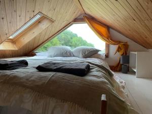 a large bed in a room with a large window at The Cabin at Shambala- now with sauna available to book! in Whitby