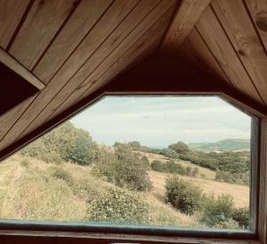 a window in a room with a view of a field at The Cabin at Shambala- now with sauna available to book! in Whitby