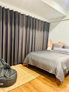 a bedroom with a bed and a black curtain at Chern Chiangmai Boutique in Chiang Mai
