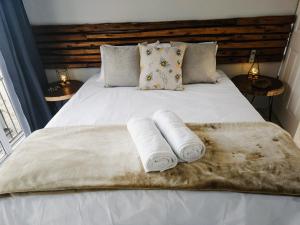 1 cama con 2 toallas y 2 lámparas en Sea Breeze Manor - Gold Unit, en East London